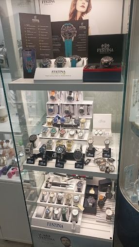 Vetrina per orologi piena di vari orologi, alcuni dei quali imballati in scatole, in un negozio.