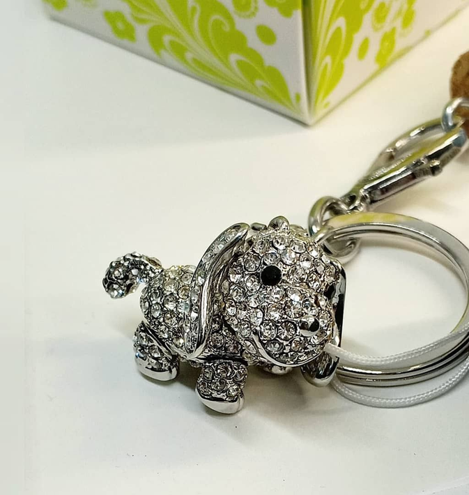Portachiavi a forma di cane in argento tempestato di strass, attaccato a un anello portachiavi.
