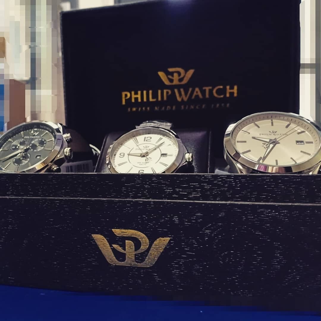 Tre orologi da polso Philip Watch in una scatola nera, con il logo del marchio in bella vista.