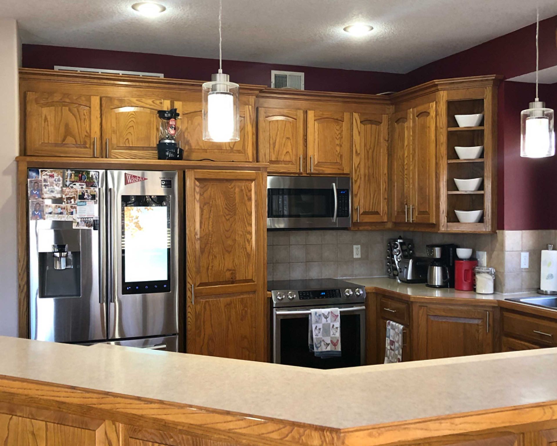 Before kitchen remodeling showing dated kitchen design with old cabinets and appliances.