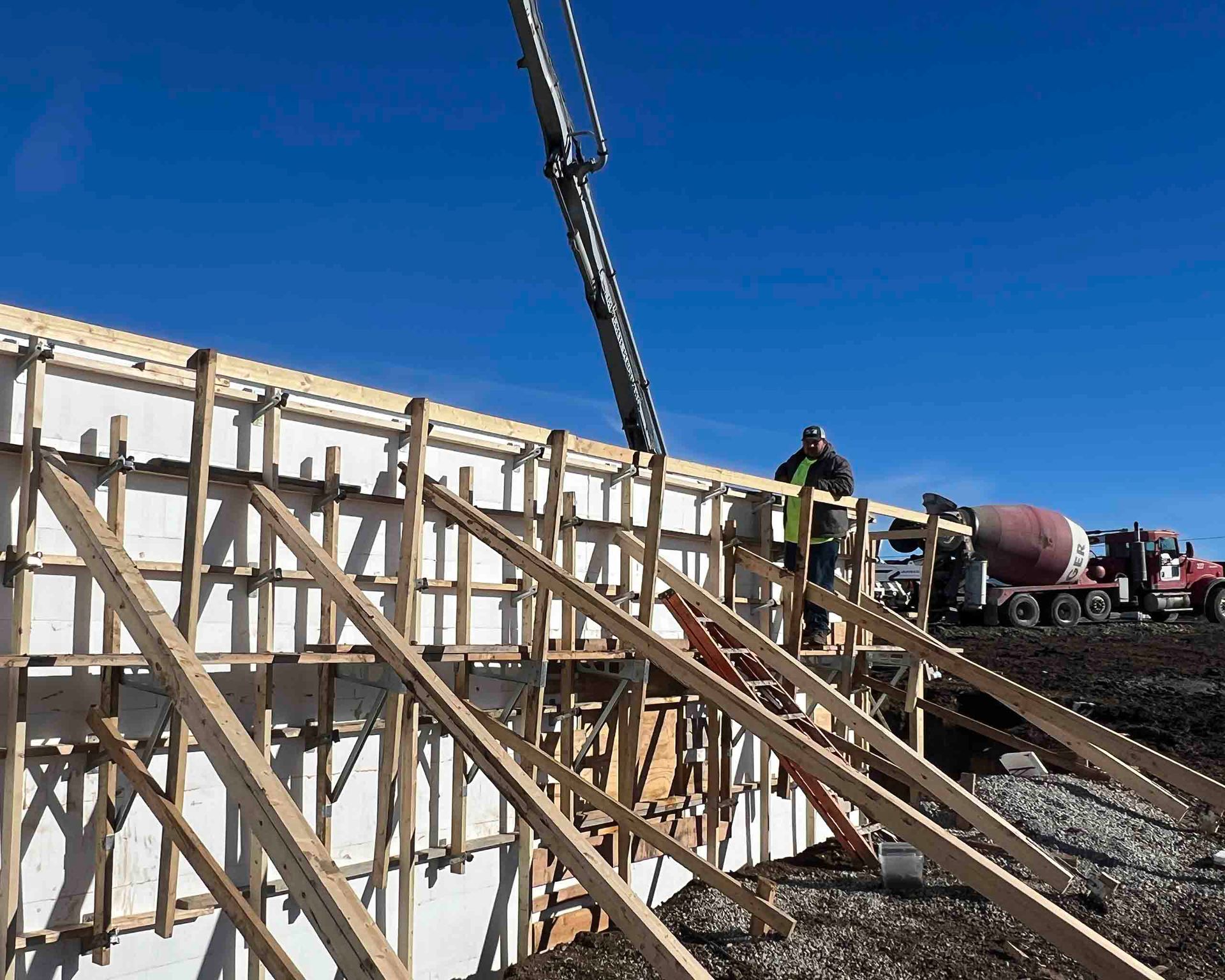Workers setting up insulated concrete forms at a residential construction site, emphasizing durability and energy efficiency