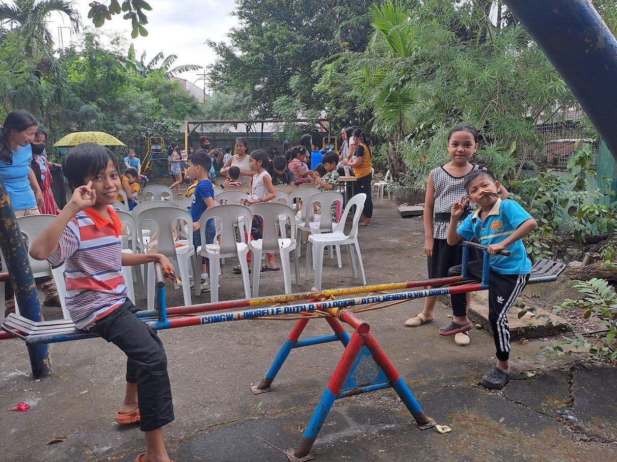 A group of children are playing on a seesaw in a park.