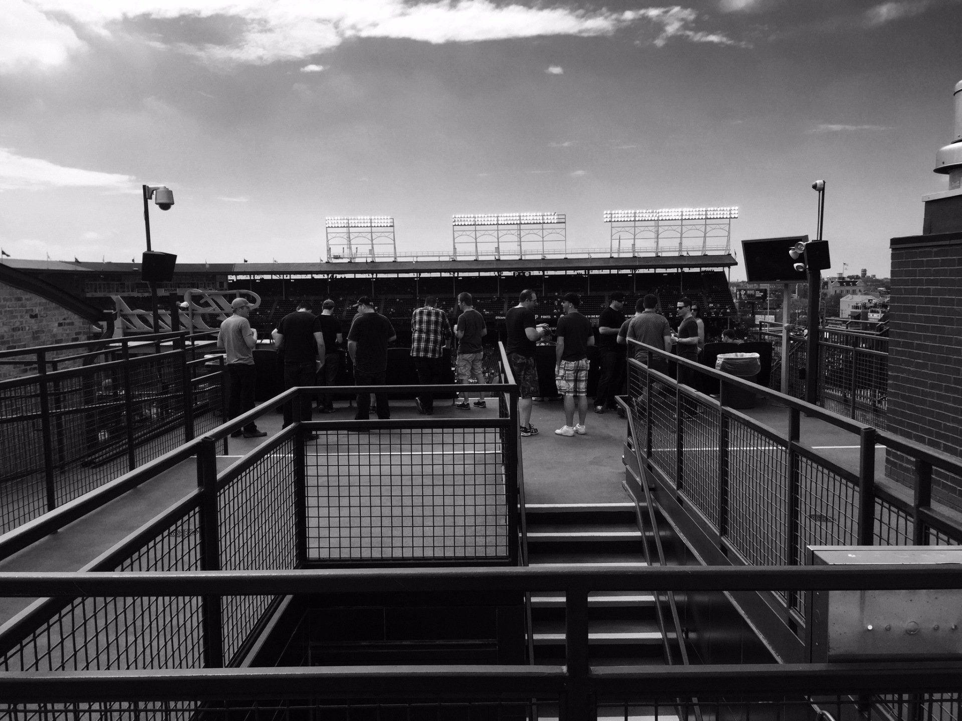 A black and white photo of people standing on a balcony