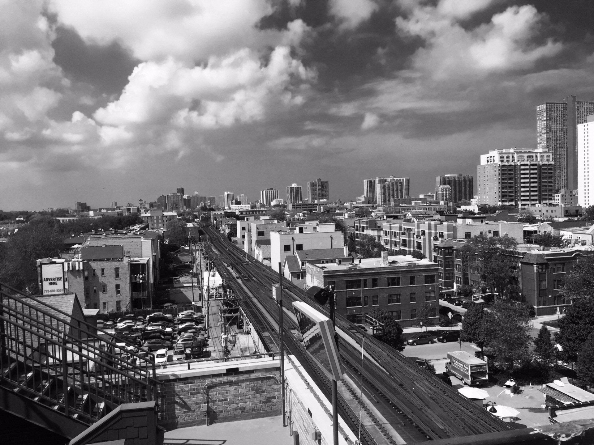A black and white photo of a city with a train going through it