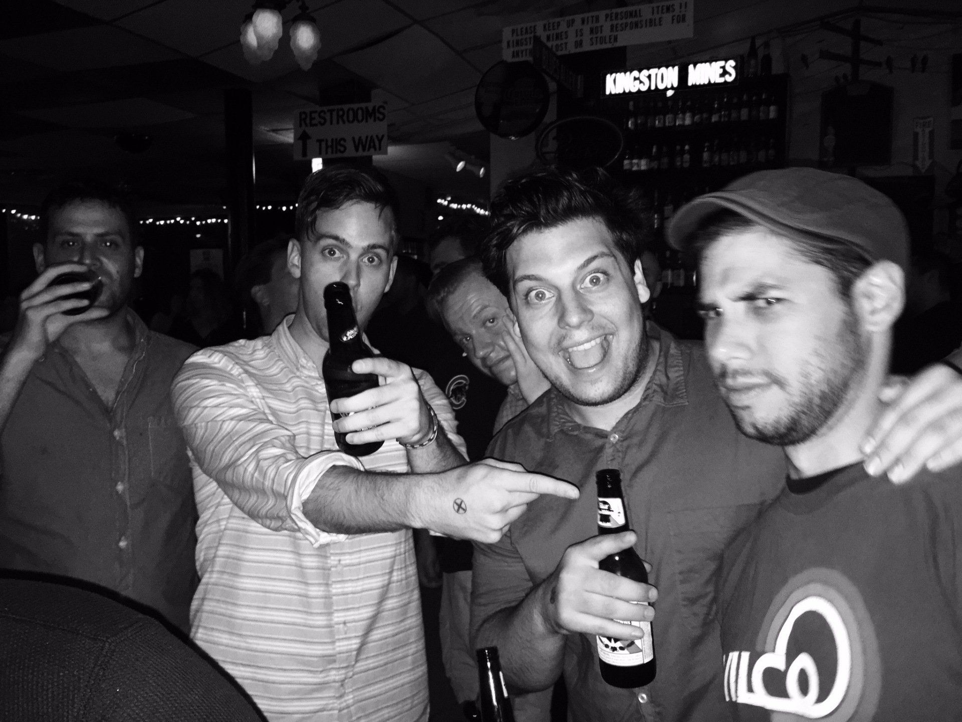 A black and white photo of a group of men drinking beer