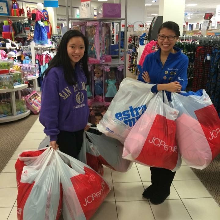 A woman in a purple san diego sweatshirt is holding a jcpenney bag
