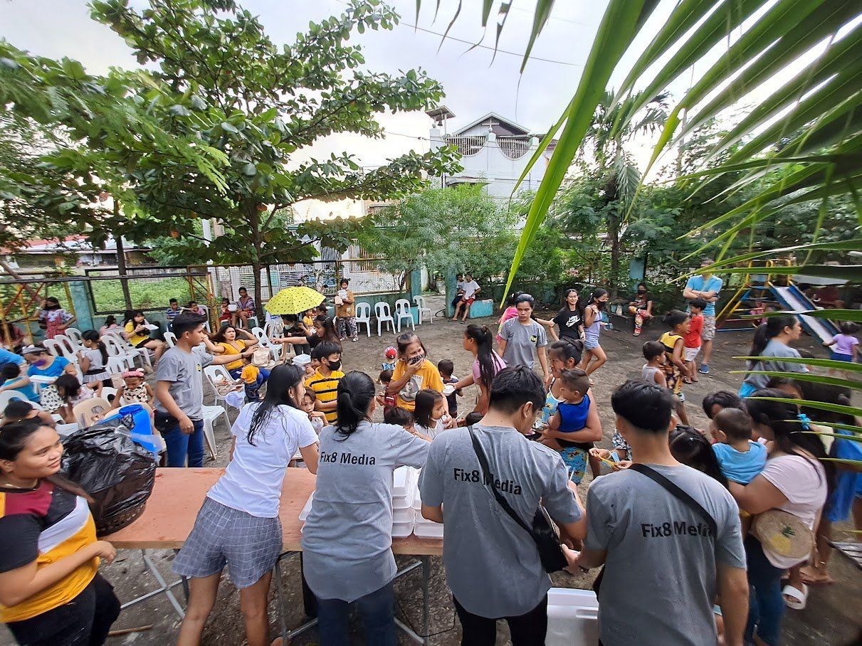 A group of people are standing around a table in a park.