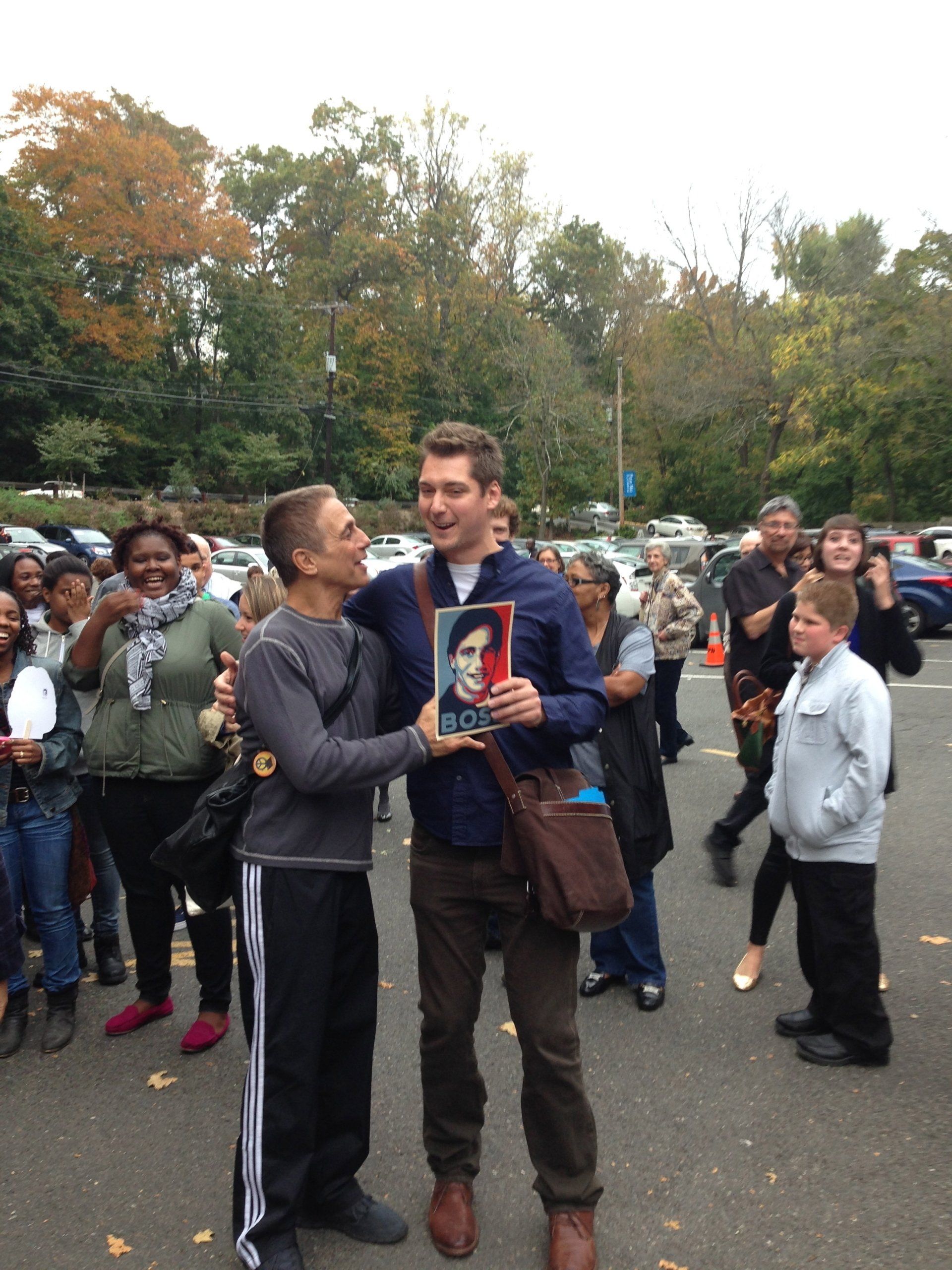 A man holding a picture of a man with the word duke on it