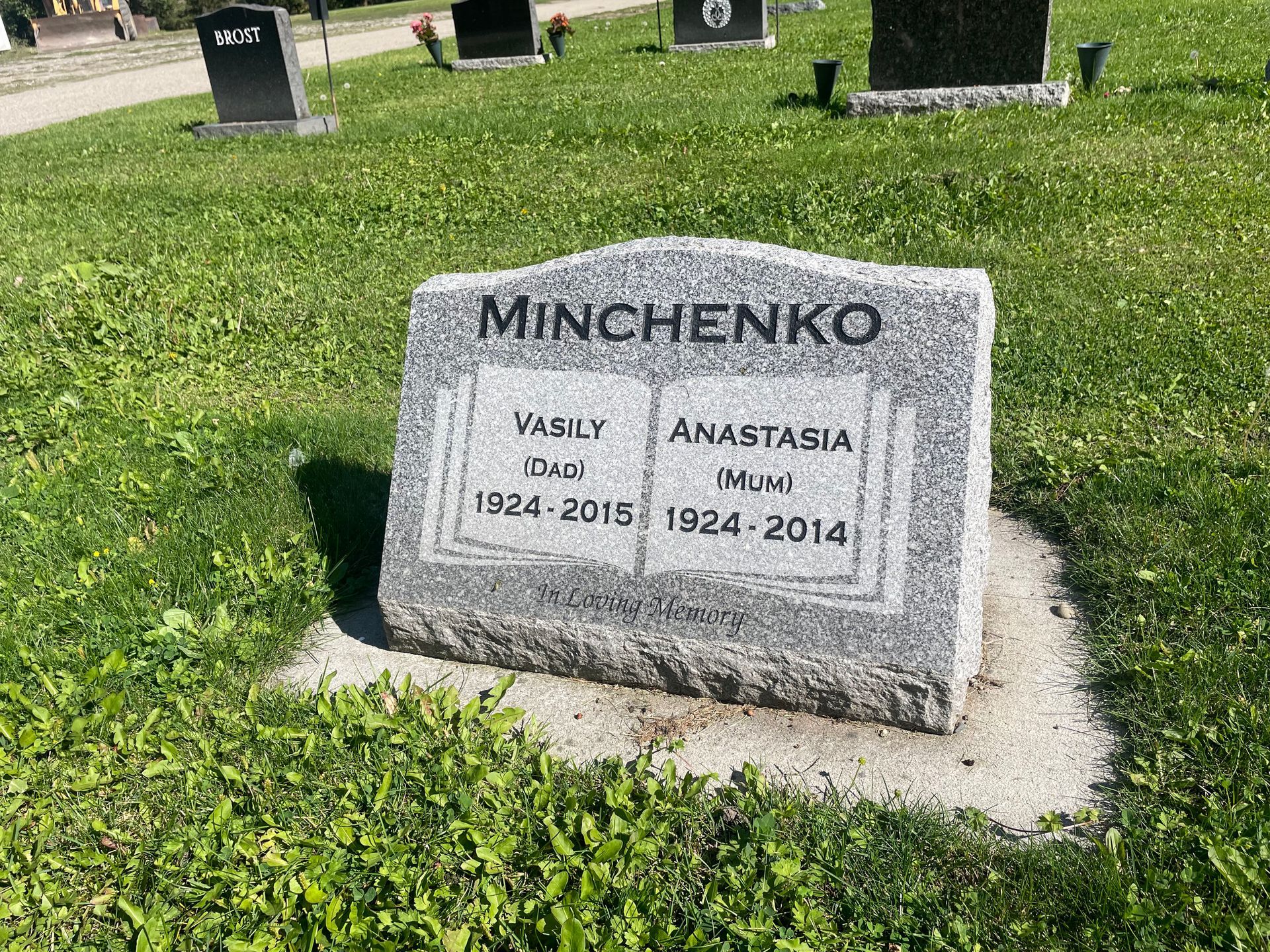A gravestone in a cemetery with a book on it.