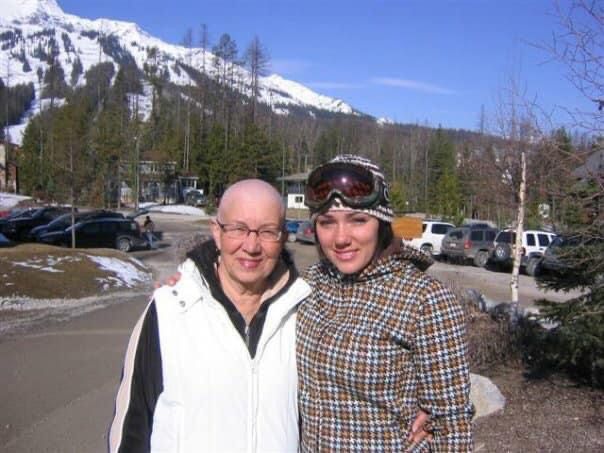 Two people posing for a picture with a mountain in the background