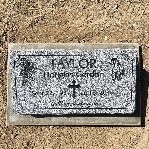 A gravestone for taylor douglas gordon is sitting on top of a dirt field.