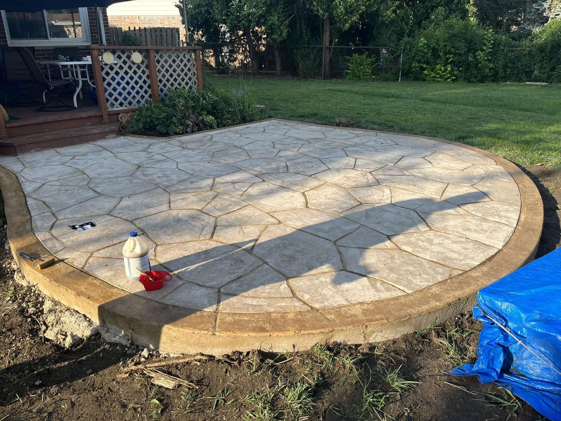 A concrete patio is being built in a backyard.
