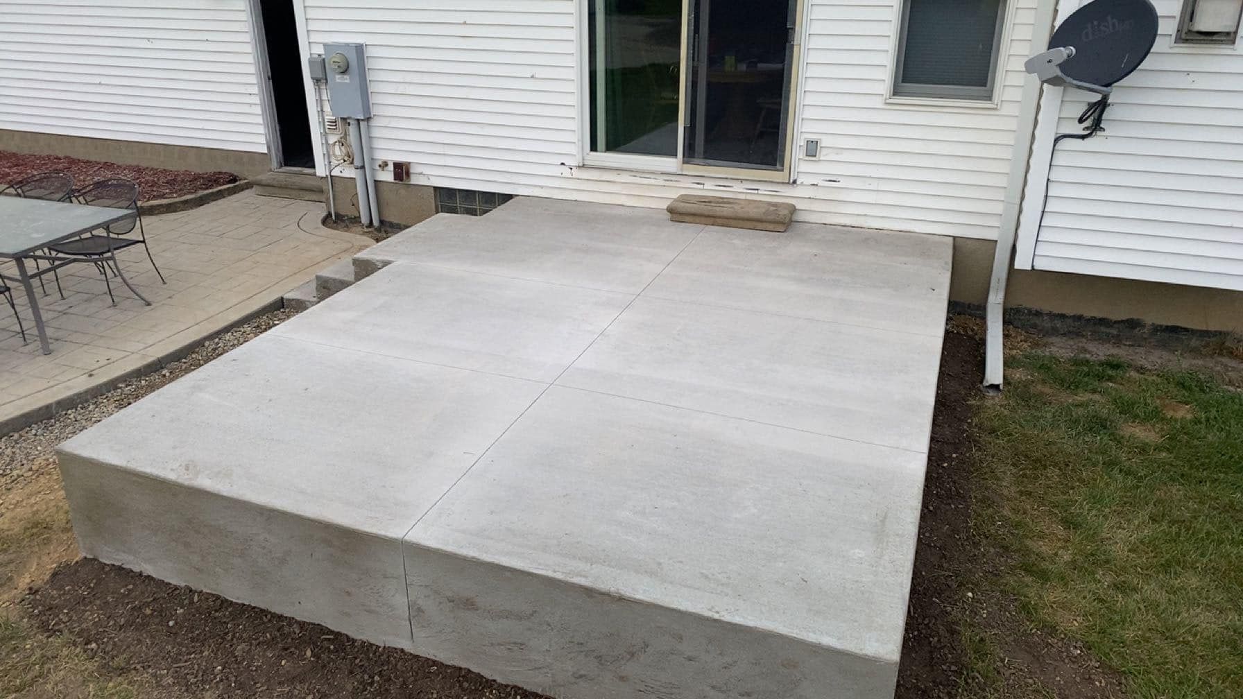 A large concrete slab is sitting in front of a house.