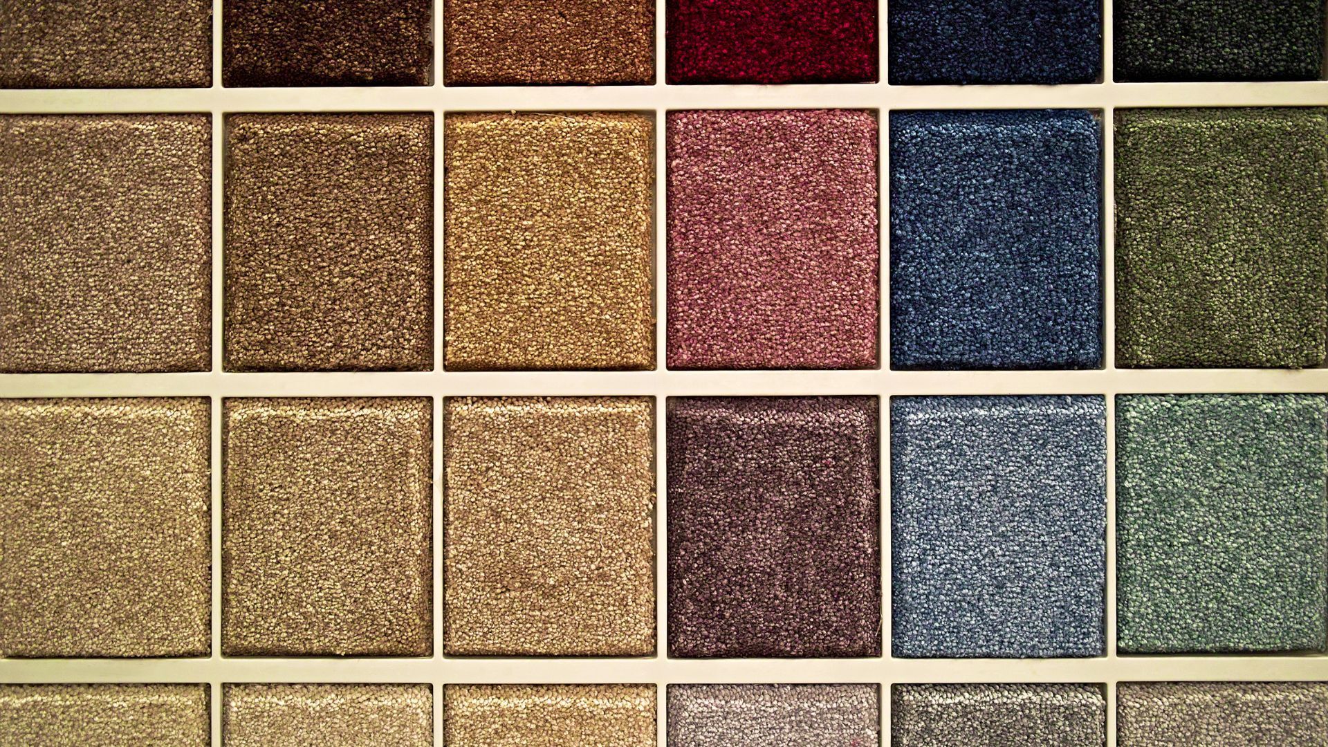 A variety of carpet samples are displayed on a table.