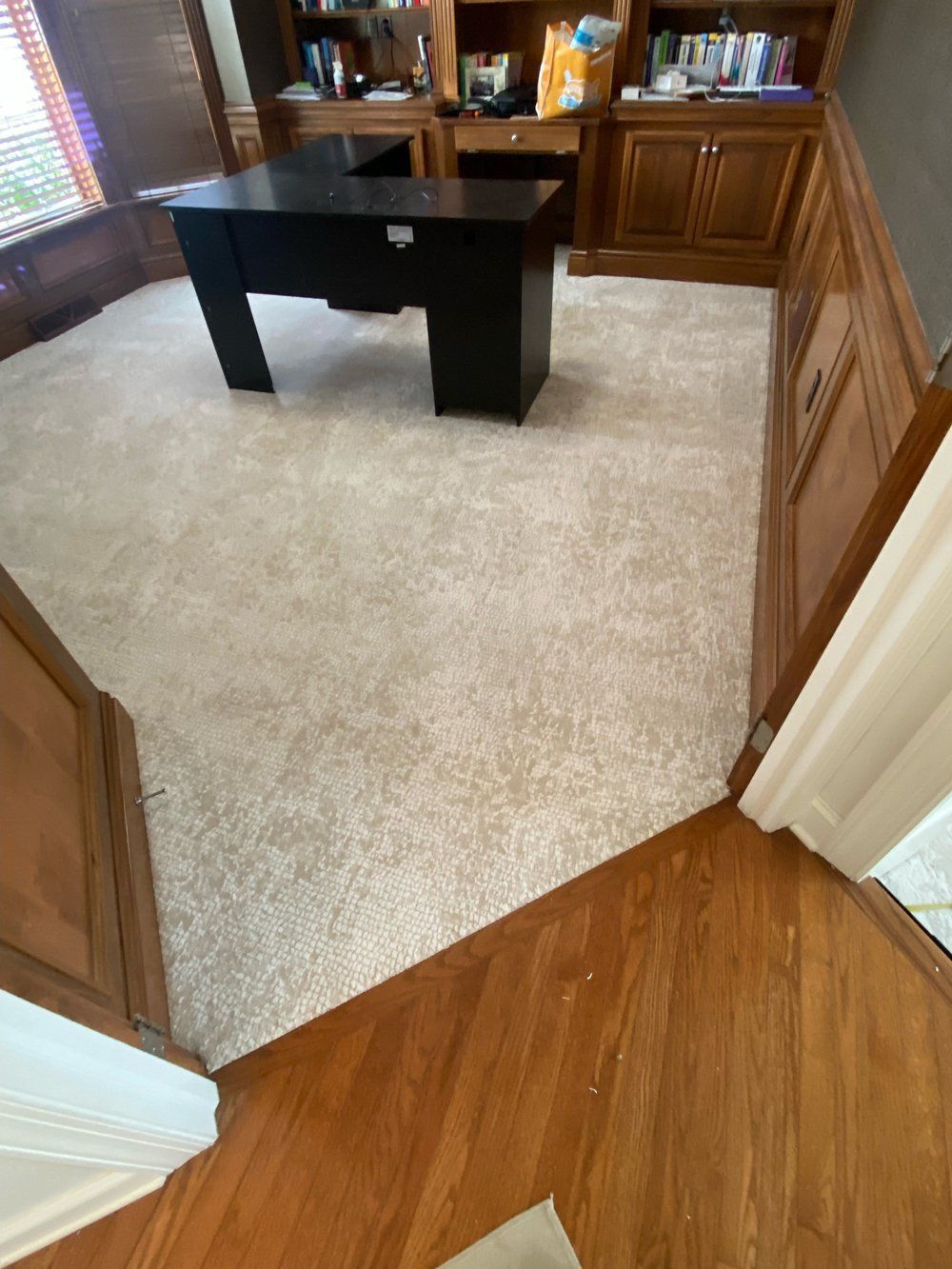 A room with a desk and a carpeted floor