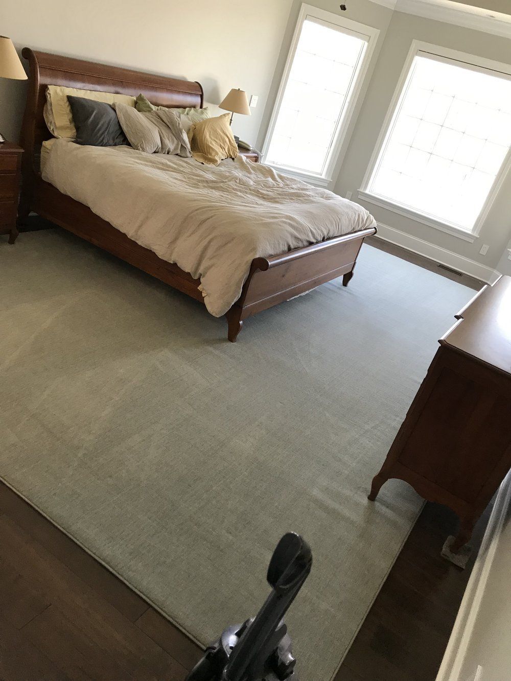 A bedroom with a large bed and a vacuum cleaner