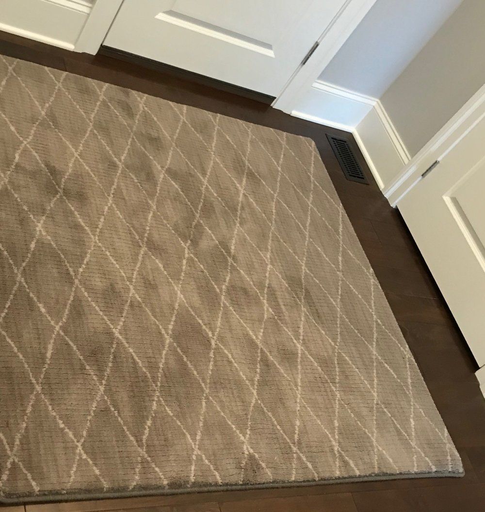 A rug is sitting on a wooden floor in a room