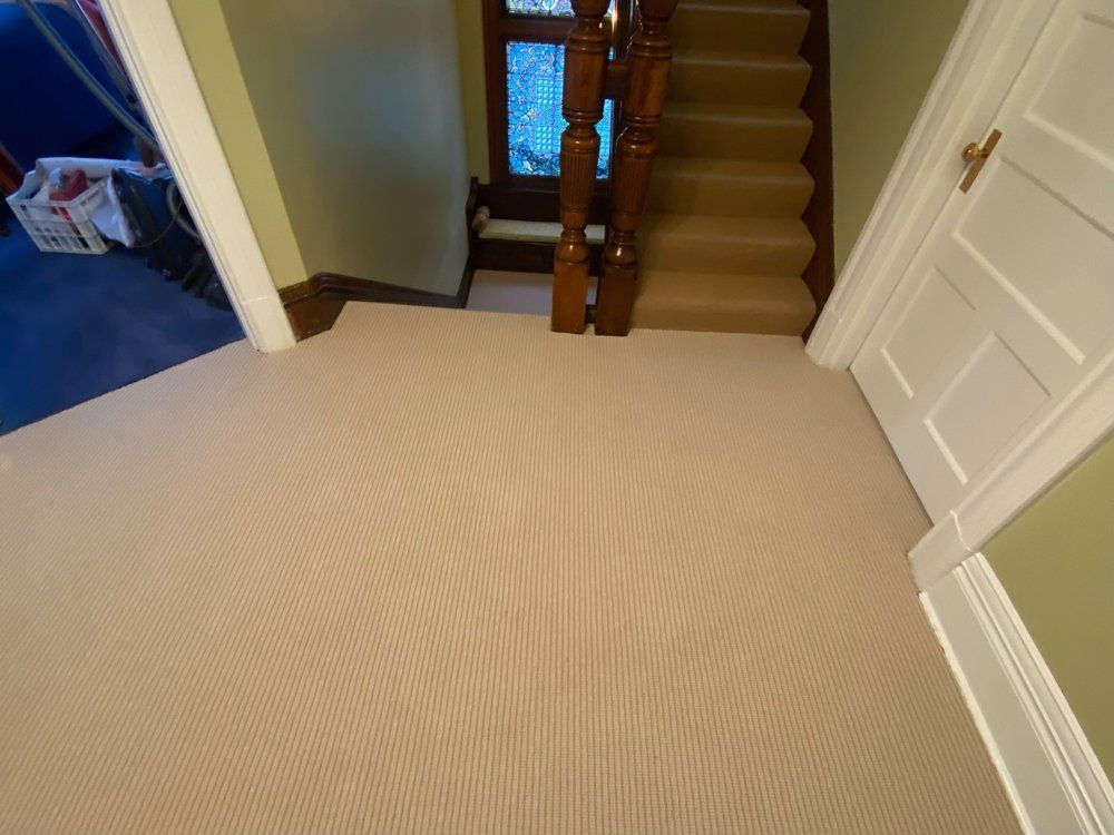 A staircase with a carpeted floor and a wooden railing