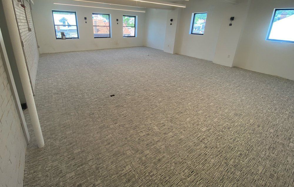 A large room with a carpeted floor and windows
