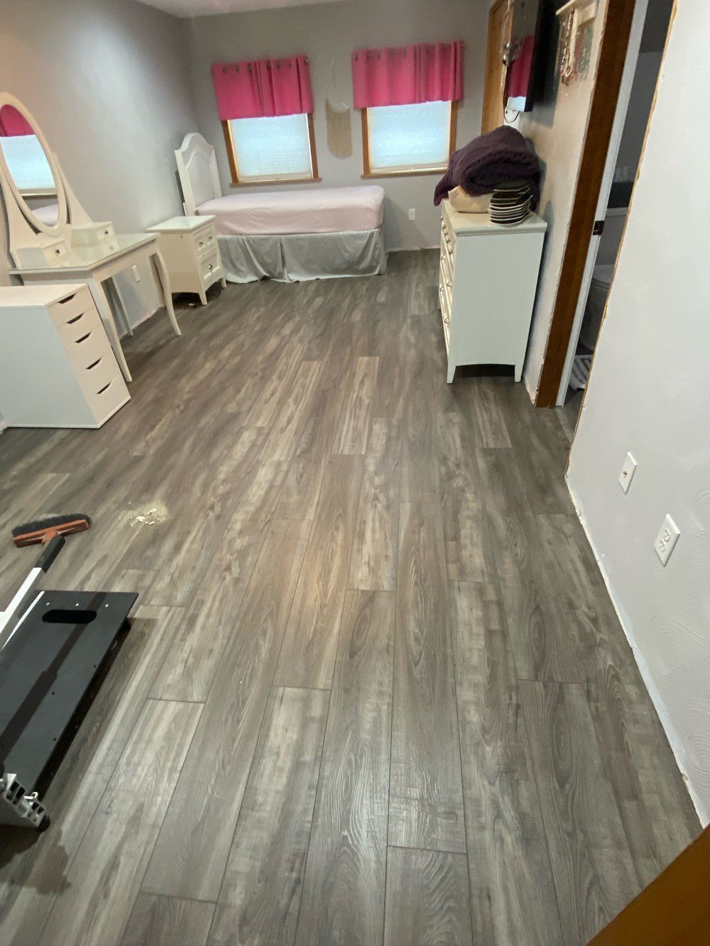 A bedroom with hardwood floors and a treadmill