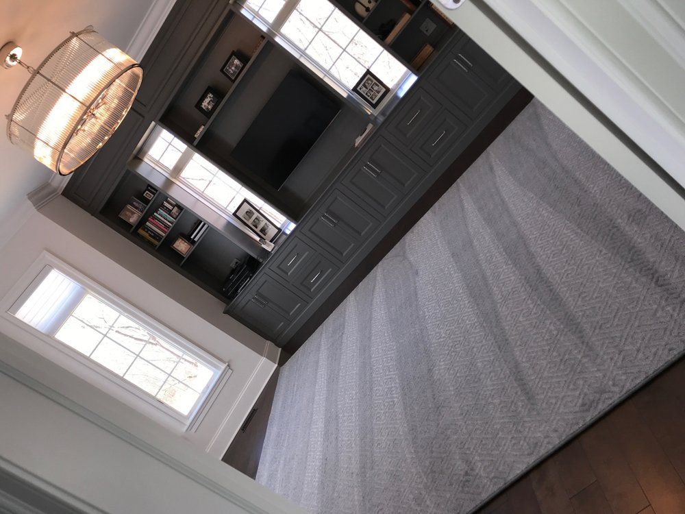 A living room with a gray carpet and a flat screen tv