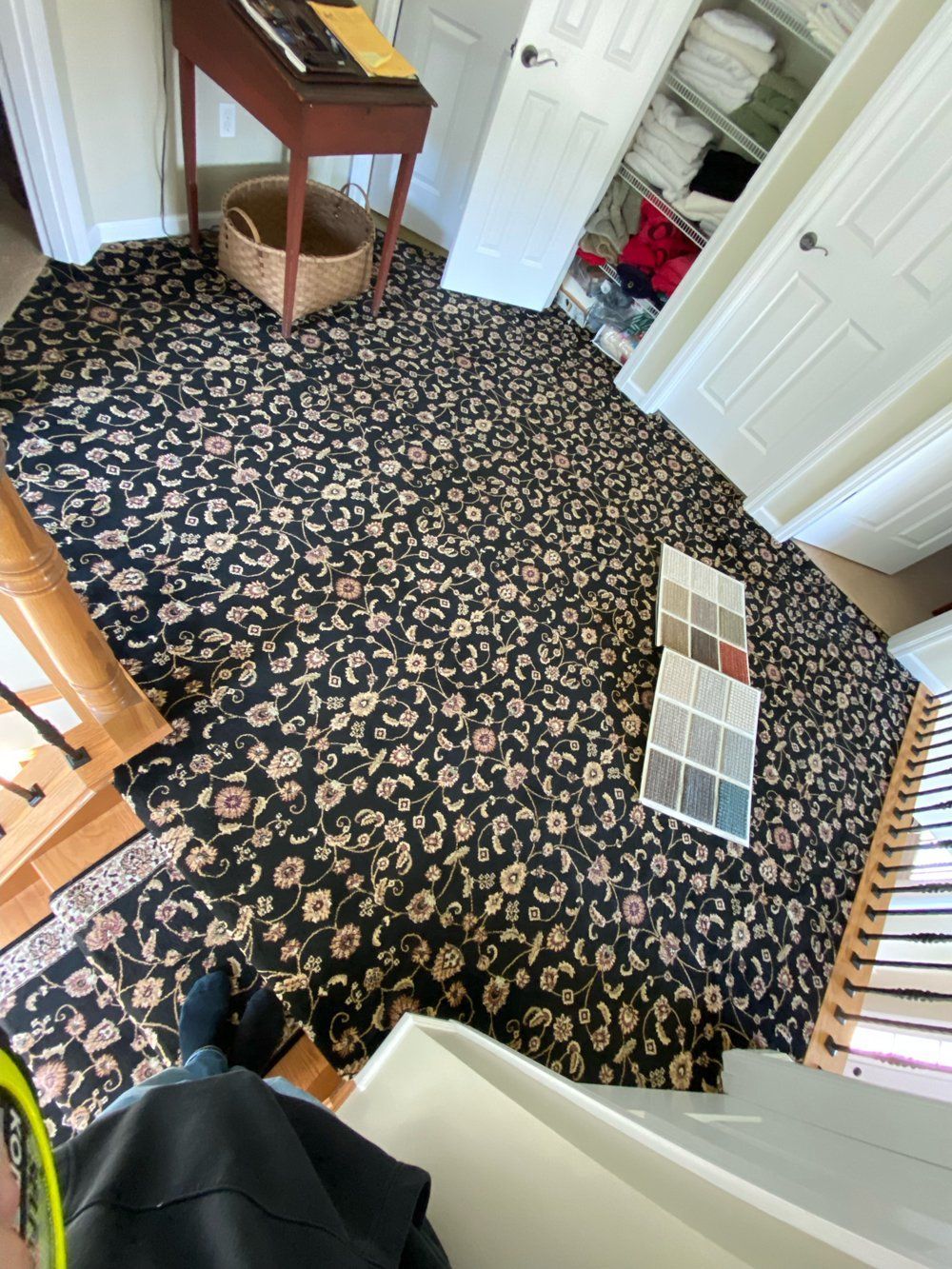 A person is sitting on the stairs in a room with a leopard print carpet.