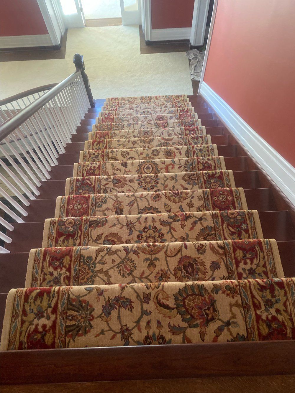 A staircase with a floral carpet on the steps