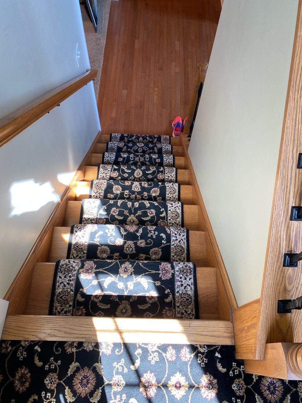 A staircase with a floral carpet on the steps