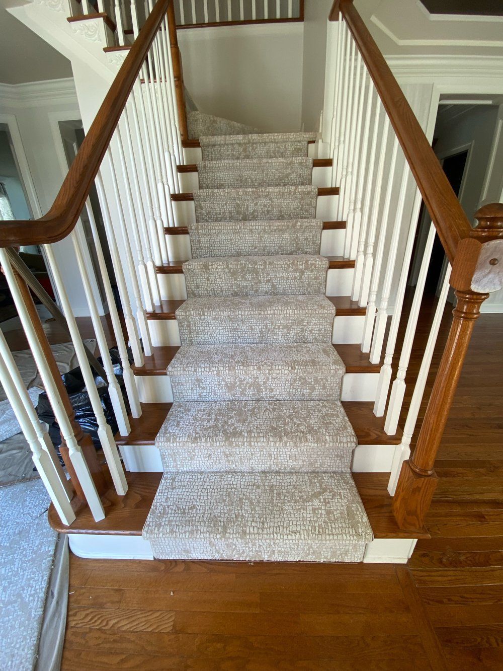 A staircase with a white railing and a white carpet