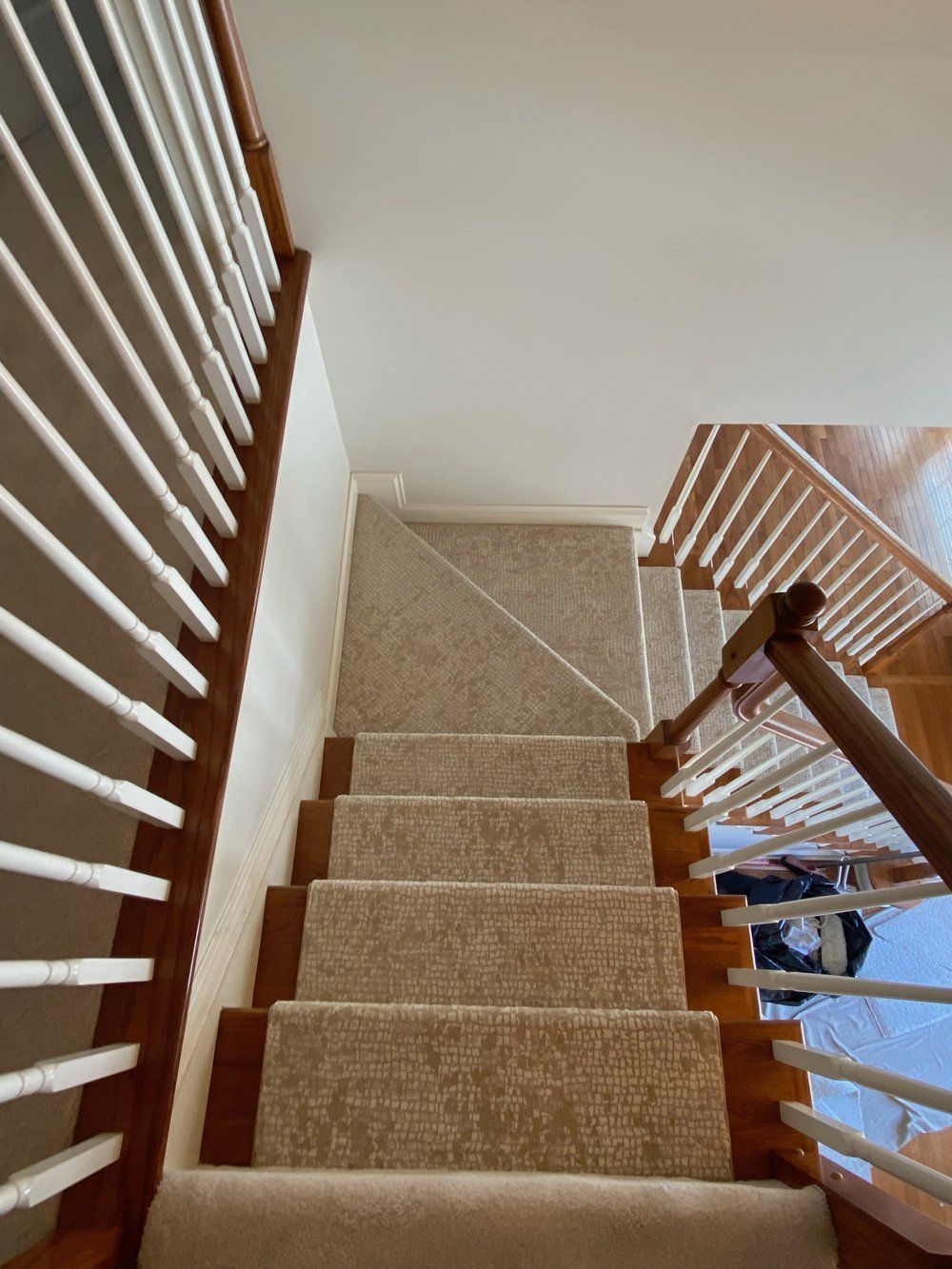 A staircase with a white railing and a beige carpet