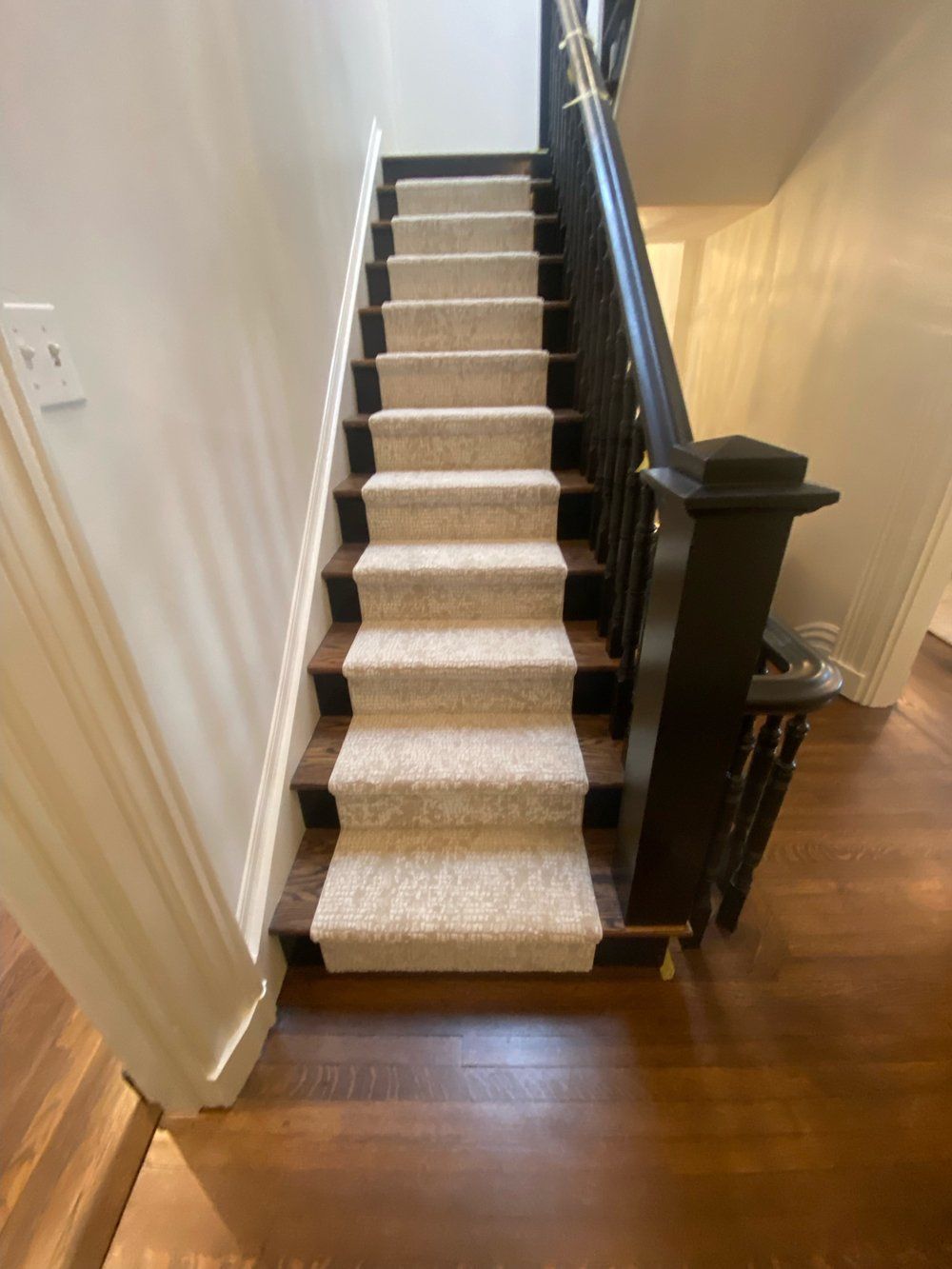 A staircase with a white carpet on the steps