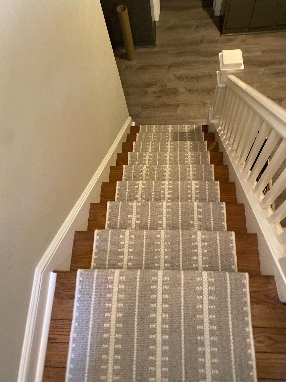 A staircase with a gray and white striped carpet