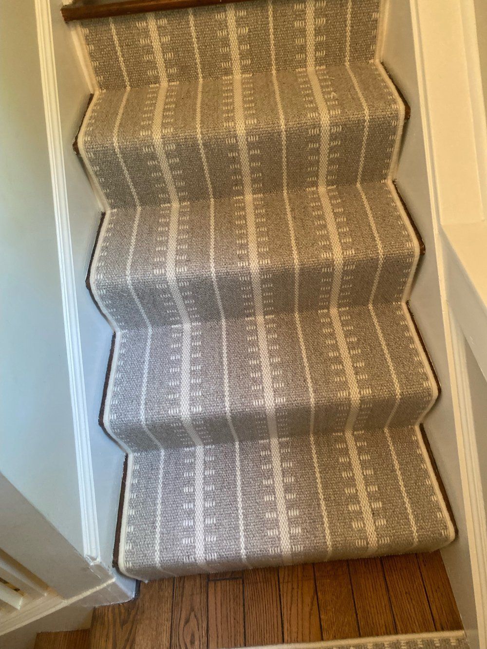 A set of stairs with a striped carpet on them