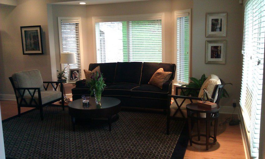 A living room with a black couch and a round coffee table