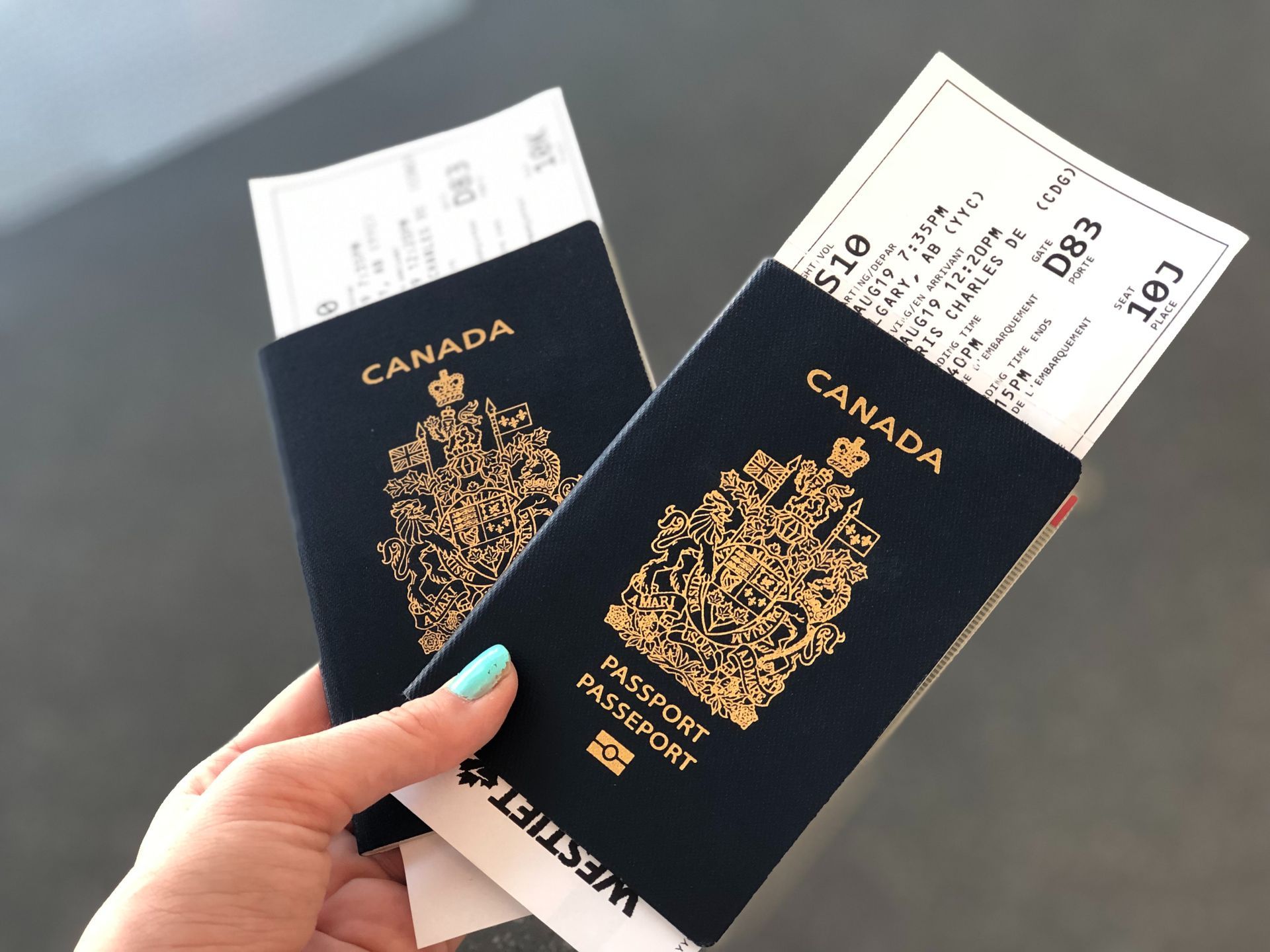 A person is holding two canadian passports and boarding passes.