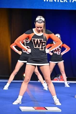 A group of cheerleaders are performing on a stage.