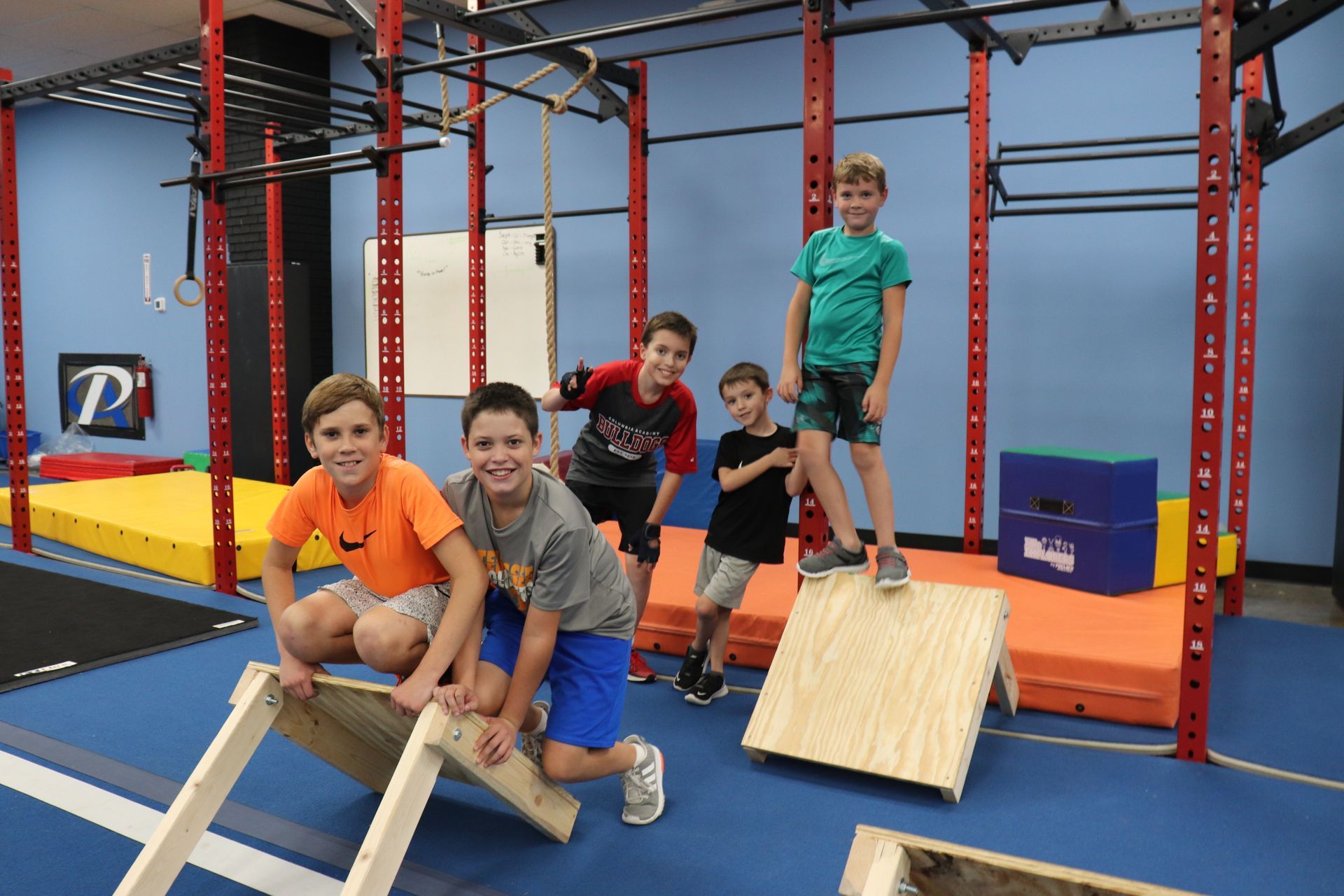 A group of young boys are posing for a picture in a gym.