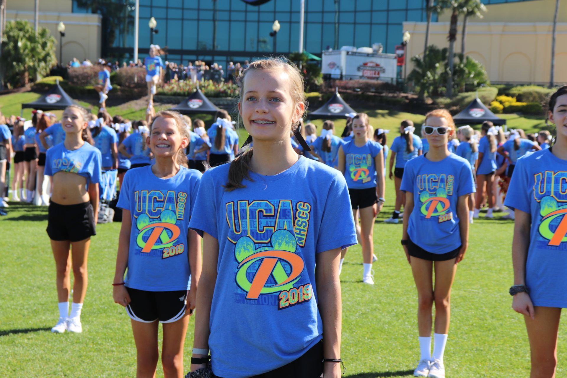 A group of cheerleaders are standing on a field.