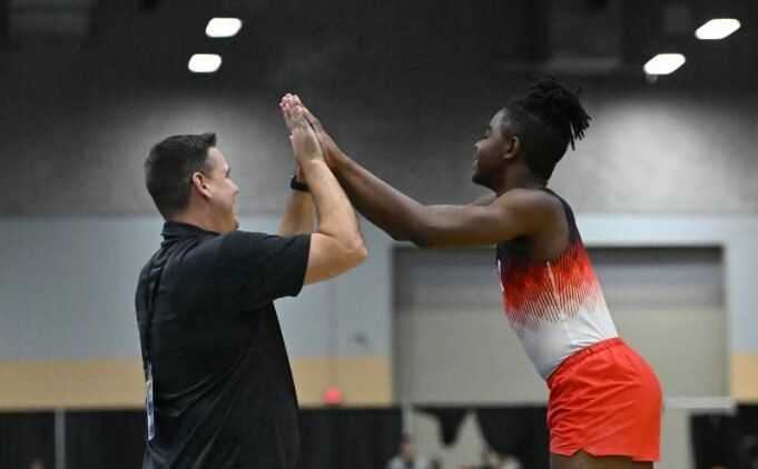 Two men are giving each other a high five in a gym.