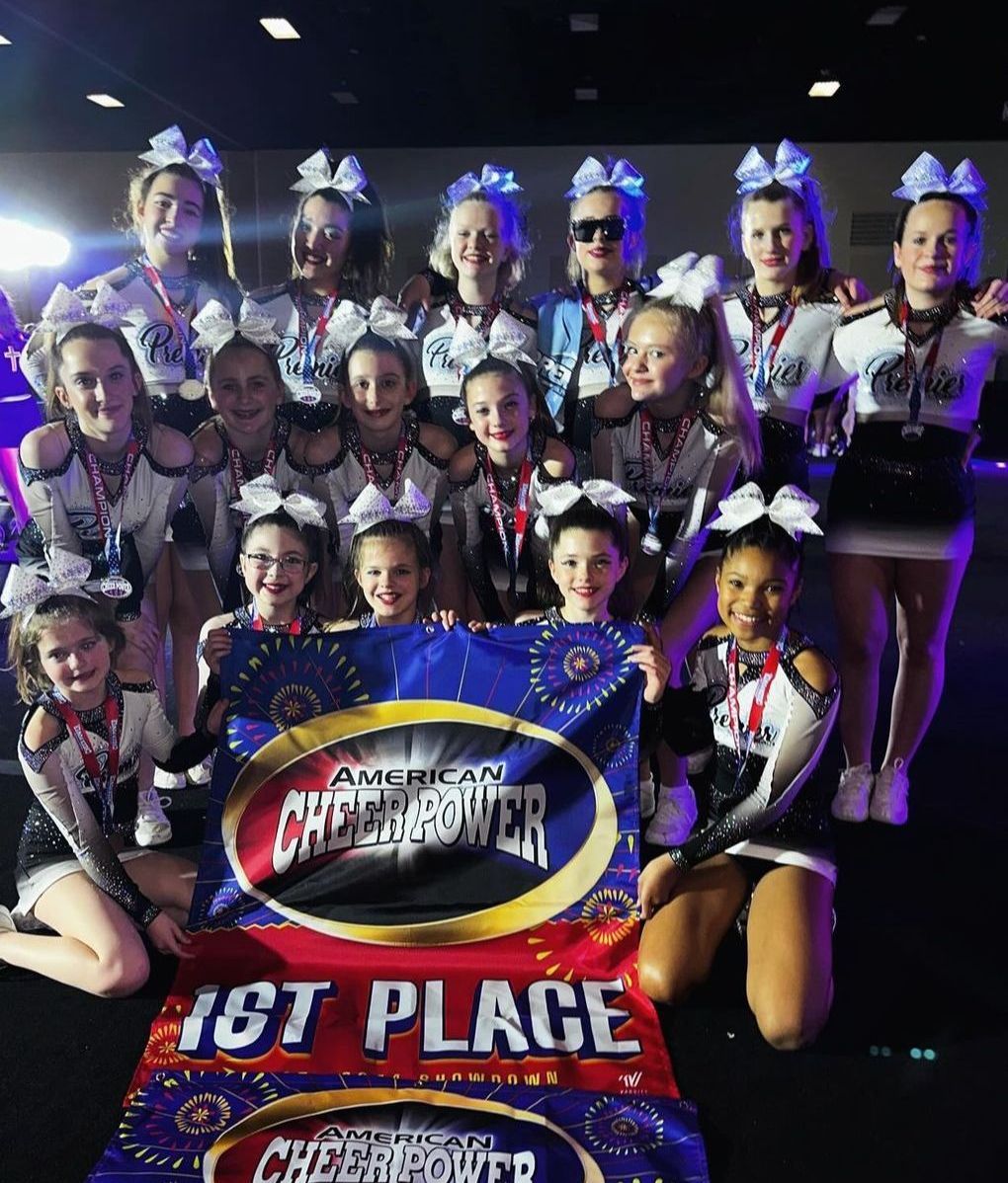 A group of cheerleaders are posing for a picture with a banner that says 1st place