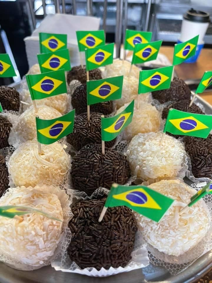 A tray of brazilian desserts with flags on sticks.