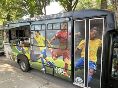 A bus with soccer players on the side is parked on the side of the road.