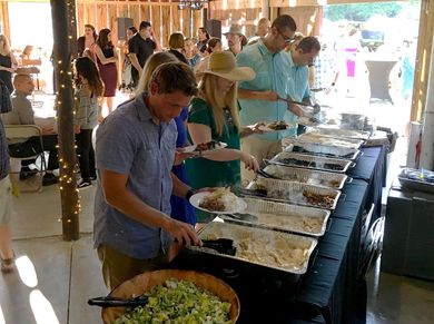 A group of people are standing in line at a buffet table.