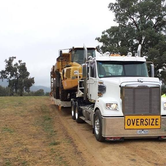 An Oversize Truck Is Carrying a Tractor on A Trailer — Albury Demolitions in Lavington, NSW