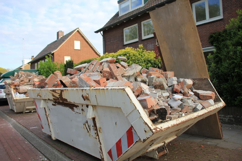 A Dumpster Filled with Bricks Is Parked on The Side of The Road — Albury Demolitions in Lavington, NSW