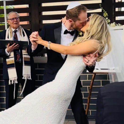 A bride and groom kiss during their wedding ceremony