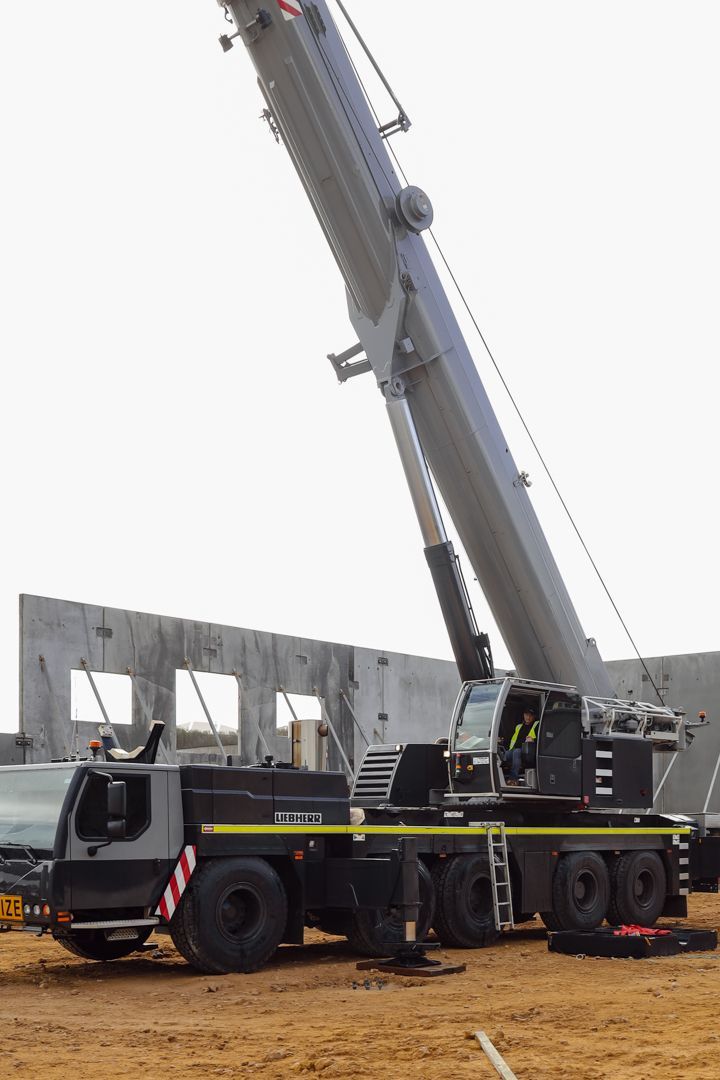 Eyecatching and colorful lifting equipment can be seen at this busy construction site. Eyecatching and colorful lifting equipment can be seen at this busy construction site.