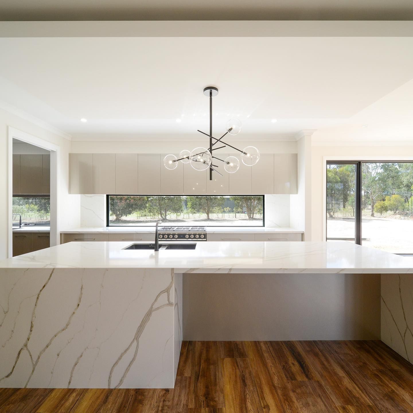 A kitchen with a large island and a chandelier hanging from the ceiling.