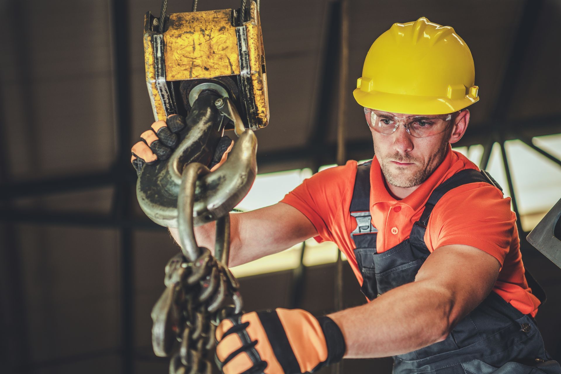 A warehouse lift operator holding a hook block.