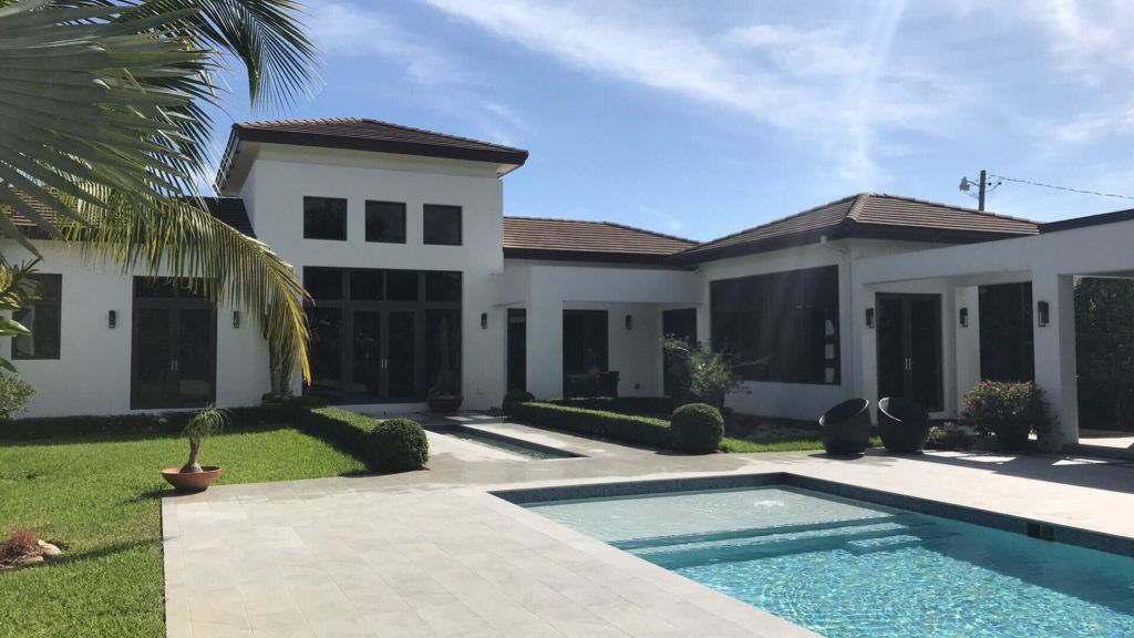 A Large White House with a Swimming Pool in Front of it - Miami, FL - Epiclean Professional Cleaning